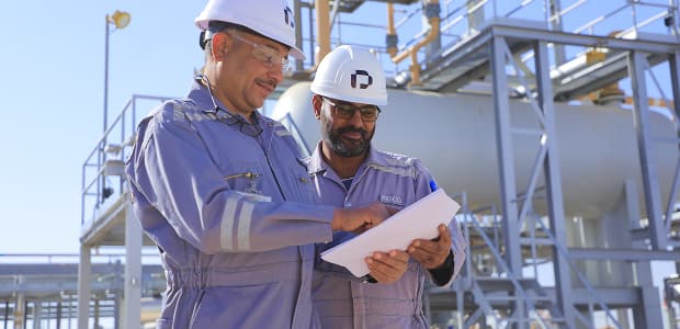 Two PESCO engineers checking plans at a process plant