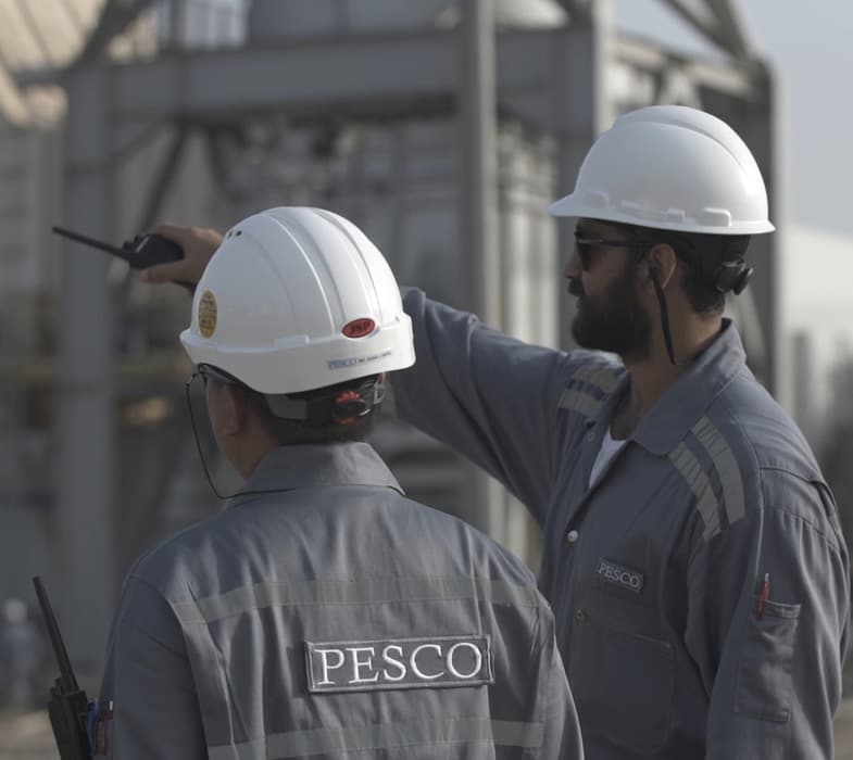 Two PESCO engineers in hard hats reviewing a plant on site